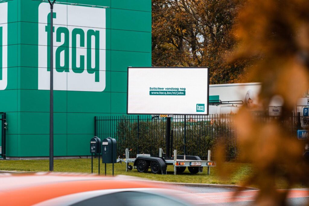 Mobiel ledscherm op aanhangwagen van MaxLED met een vacaturebericht voor Facq in Merelbeke